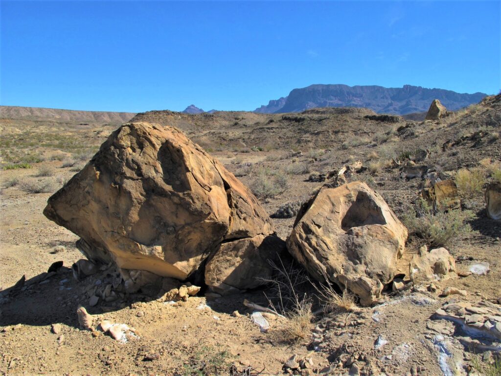 Boulders in the desert with the mountains in the background in Big Bend National Park